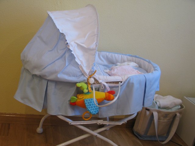 我が家の赤ちゃん用ベッド。お客さんが来た時に赤ちゃんを見せるのにも便利です。近くにあるバッグはLand's Endのもので、以前イニシャルを入れて注文しました。おむつや赤ちゃん用品をまとめておくのに便利です。