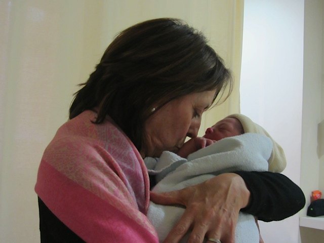 生まれたばかりの孫にキスをする義母。